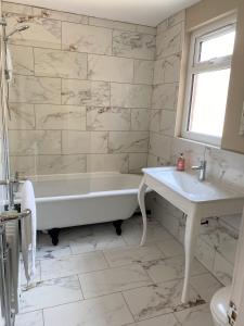 利物浦Beautiful Victorian Townhouse的白色的浴室设有浴缸和水槽。