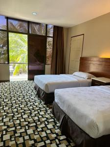 珍南海滩马里贝斯特度假村的酒店客房设有两张床和大窗户。