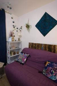 利布尔讷Studio cosy au calme的卧室内的一张带紫色床单和枕头的床