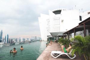吉隆坡The Common Room @ Regalia的一座建筑物屋顶上的游泳池,里面的人