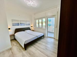 格拉多Condominio Martini的一间卧室设有一张床和一个大窗户