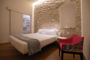 莫迪卡Keys of Sicily的一间卧室配有一张大床和一张红色椅子