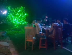 宁平Trang an green river homestay的一群人晚上坐在水族馆的桌子上