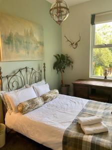 RobyLyndhurst - Victorian villa with heated pool的一间卧室配有一张带白色床单的床和一扇窗户。