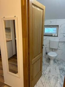 DezmirGiulia Home的一间带卫生间和木门的浴室