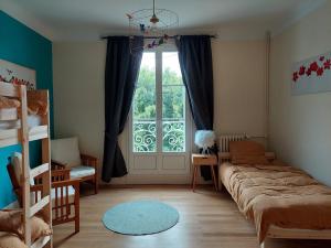 茹埃莱图尔La Maucannière的一间卧室设有一张床和一个大窗户