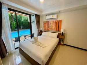 Ban Bo Sai KlangMai Khao Beach Condotel - family condo in 600 meters to beach的一间卧室设有一张床和一个大窗户