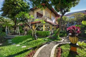 勒吉安Royal Tunjung Hotel & Villa Legian - CHSE Certified的鲜花屋前的走道