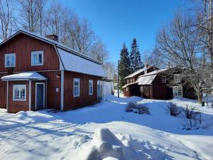 PorrasPortaan Nahkurinverstas的两座建筑物旁的雪地里的一个红色谷仓