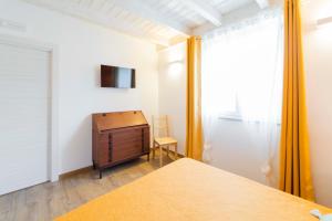 Castiglione ChiavareseAgriturismo Torsivì的一间卧室配有一张床、一个梳妆台和电视。