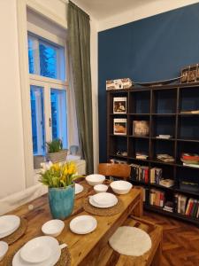 维也纳4 seasons apartment的餐桌上摆放着白色的盘子和鲜花