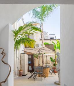 锡拉库扎卡萨瑟莱斯特公寓的一个带桌椅和棕榈树的庭院