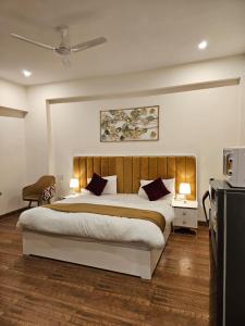 古尔冈Amahi Inn的一间带大床和电视的卧室