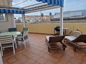 贝尼卡洛Pareado Mediterrania的庭院配有桌椅和遮阳伞。