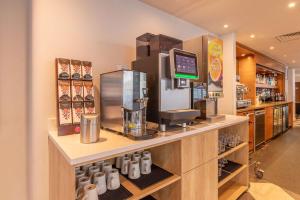 莱斯特莱斯特市中心安可华美达酒店的柜台上的咖啡店,配有咖啡机