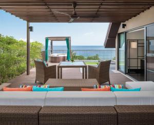 卡马拉海滩Hyatt Regency Phuket Resort - SHA Extra Plus的平台上设有带沙发和桌子的庭院