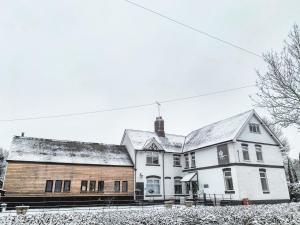 LettonThe Swan Inn Letton的一座白色的大房子,屋顶上积雪