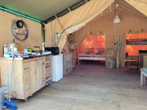 Saint-Martin-des-BesacesTente Lodge Safari的帐篷设有厨房,卧室设有1张床