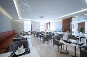 艾卜哈دانة المروج للأجنحة الفندقية Danat Almourouj Hotel Suites的一间在房间内配有桌椅的餐厅