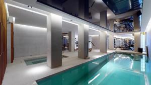 马德里Increíble villa de lujo的一座带游泳池的大楼内的大型游泳池