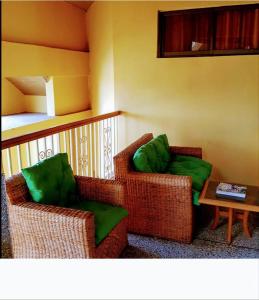 特马Room in Guest room - Renajoe Exclusive Guesthouse Tema Community 9的两把椅子,绿色靠垫,坐在房间里