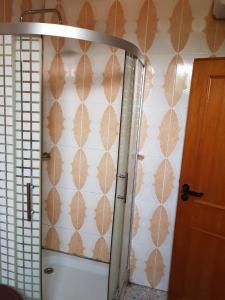 特马Room in Guest room - Renajoe Exclusive Guesthouse Tema Community 9的一间带卫生间的浴室和一堵带叶子的墙壁