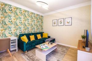 布达佩斯Hillside Lodge的客厅配有绿色沙发和桌子
