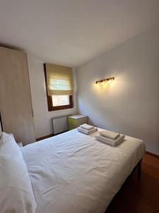 特伦普Allotjament Sanuy a Tremp的卧室配有白色的床和2条毛巾