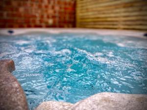 布莱克浦Brand new luxury 3 Bed Hot Tub House in Blackpool的客房内的浴缸里装满了蓝色的水
