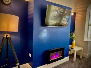 布莱克浦Brand new luxury 3 Bed Hot Tub House in Blackpool的一间客房内的蓝色墙壁和壁炉