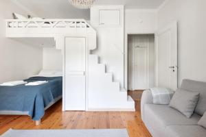 赫尔辛基WeHost Spacious Studio for 5 with a Kitchen的一间白色的卧室,配有床和楼梯
