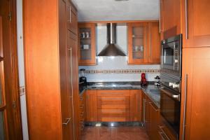 康达Casa Villa Mey的厨房配有木制橱柜和黑色冰箱。