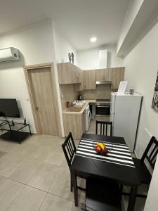 利马索尔Modern City Center Apartment Saripolou 2的厨房配有黑色桌椅和冰箱。