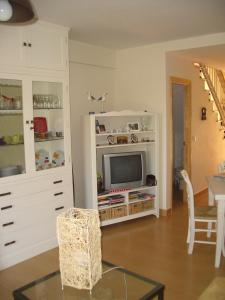 韦尔瓦ADOSADO FAMILIAR的一间客厅,客厅配有白色橱柜内的电视