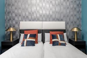 马德里Beautiful Room in Heart of Madrid的一间卧室配有两张带枕头和两盏灯的床。