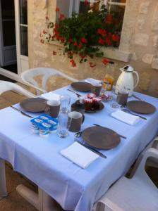 Coye-la-Forêt莱斯雷音特斯酒店的一张桌子,上面有蓝色的桌布和盘子