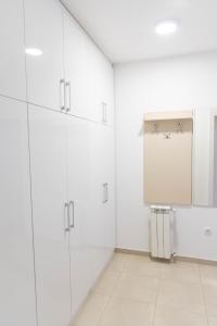 ObrenovacApartman Exclusive的白色的厨房,配有白色的橱柜和黑板