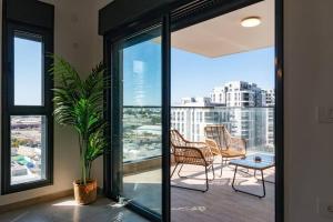 Or YehudaO&O Group - Luxury APT/3 BR/New Tower/Parking的阳台配有椅子和盆栽植物