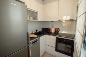 贝尔格莱德GARDOS BAUHAUS Apartment的厨房配有白色橱柜和炉灶烤箱。