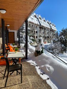 福米加尔提洛尔酒店的雪地里带桌椅的庭院