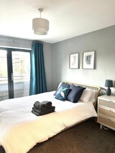 德比Stylish 2 Bed Apartment Derby的一间卧室配有一张带蓝色窗帘的大床
