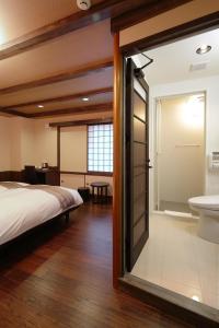 京都京町家樱花邸日式旅馆的一间卧室配有一张床,浴室设有水槽