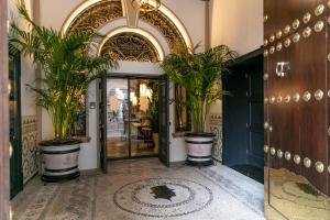 塞维利亚Hotel Casa Palacio Don Ramón的植物盆栽建筑的入口