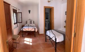 ArboleasLavender Lodge Almeria的一间设有两张床和一张桌子的房间