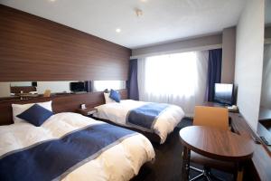 岐阜岐阜伊尔克雷多酒店的酒店客房设有两张床和一张桌子。