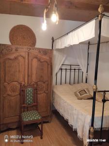 Angel's Traditional House的一间卧室配有一张天蓬床和一把椅子