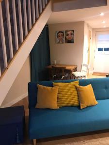 埃克塞特Rural Devon retreat in stunning Exe Valley.的客厅里配有带黄色枕头的蓝色沙发