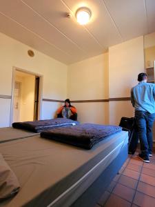 布永奥伯格新布龙青年旅舍的两人站在带两张床的房间