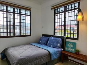 诗巫Grand Height Homestay 3A 10pax 4Rooms的一间卧室配有一张带蓝色枕头的床和窗户。