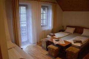旧柳博夫尼亚Penzión Dinda的一间卧室配有一张床、一张桌子和两个窗户